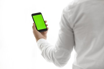 Close-up of male hands using smartphone near the window. Close up. Tracking motion. Vertical. pants.
