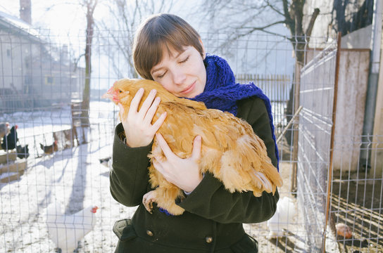 Young woman hugging chicken