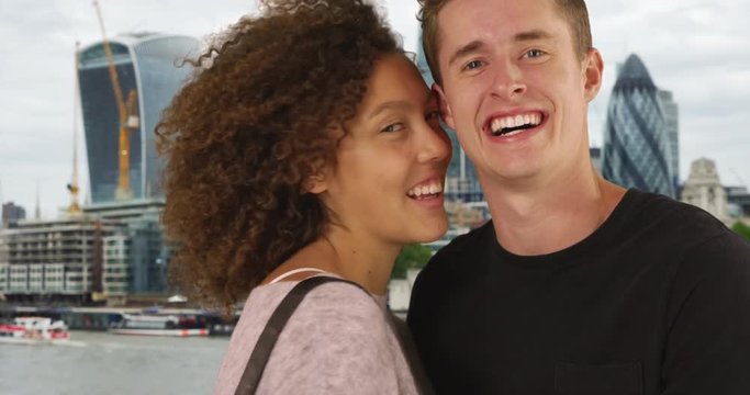 Close up of cheerful couple in London, smiling at camera, Portrait of happy male and female with London cityscape in background, 4k