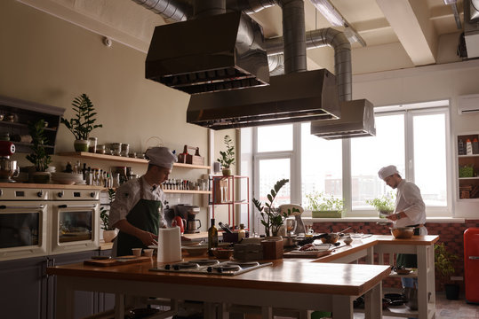 Two adult cooks working in restaurant