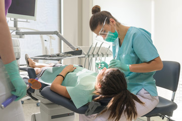 Orthodontist treating her patient in dental office