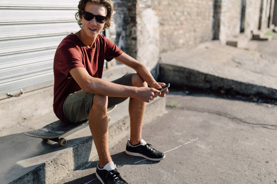 Teenager skater using a smartphone on the street