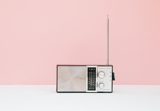Vintage transistor radio in front of pink background