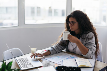 Woman working with laptop at home office.