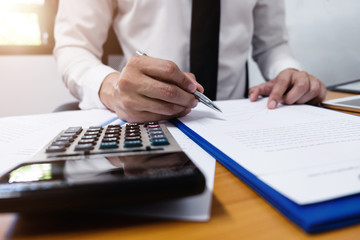 Businessman is using a pen for financial data analyzing counting