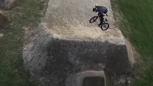Extreme sport BMX biker doing. a 360 no hander on a dirt jump aerial