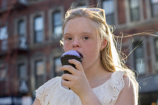 Teenager eating ice cream in an urban environment.