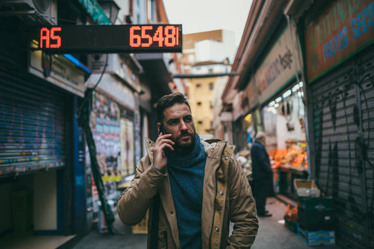 Handsome Bearded Man with Brown Coat talking on the phone