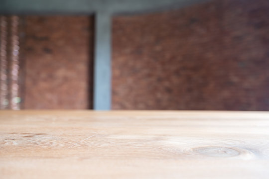 Closeup image of vintage wooden table with blur brick wall background