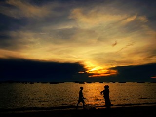 Pattaya, THAILAND - MAY 19, 2018: Silhouette of people having sunset beach in summer vacation as twilight times. Many tourists visit here. View for seascape. Travel concept. Space for text in template