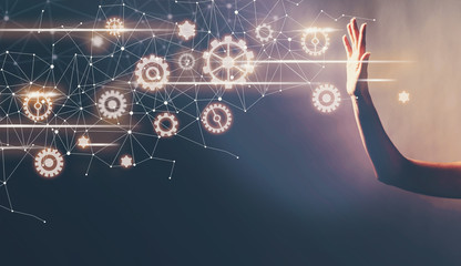 Gears with a hand in a dark light background