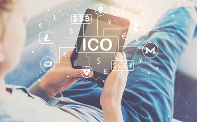 Cryptocurrency ICO theme with man using a tablet in a chair