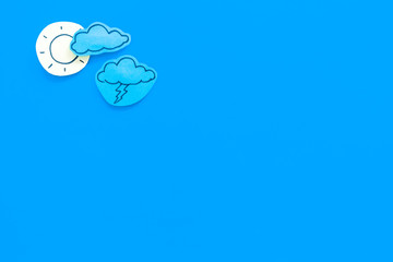 Clear and cloudly weather icons on blue background top view copy space