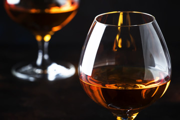 Cognac in a glass, dark background, selective focus