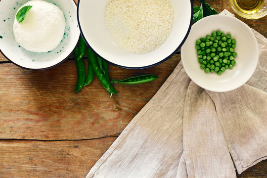 Set ingredients cooking vegetarian risotto green peas mint goat cheese wooden rustic copy space table top view Healthy food concept