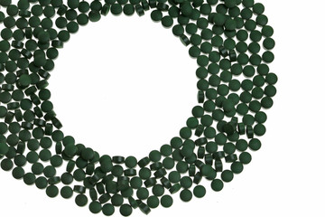 Algae spirulina in tablets close-up.round frame of spirulina tablets  on white background.spirulina Mockup.dietary supplement.Super food