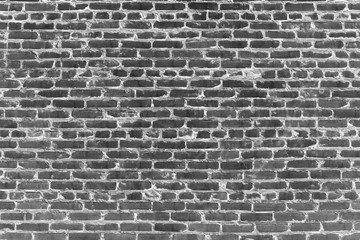 Fototapeta na wymiar Old realistic brick wall made of black brick. Burnt uneven brickwork.