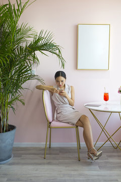 One young asian woman in pink cafe