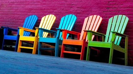 Foto auf Acrylglas colorful chairs outside by brick wall © vasanth