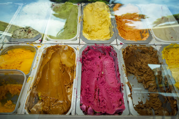 Clear glass showcase showing variety of delicious colorful ice cream flavors, blueberry, coffee, chocolate, vanilla, etc., Cappadocia