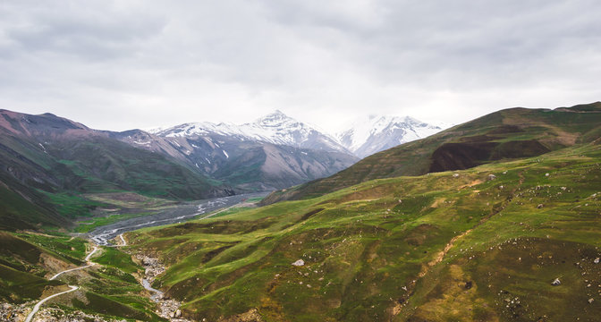 Beautiful view of the snow-covered and vegetated Caucasus Mountains