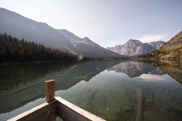 Pier and lake with reflection of mountain landscape