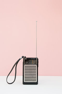 Vintage transistor radio in front of pink background