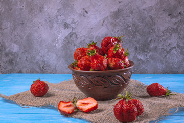 Strawberry on a blue surface in a bowl - Powered by Adobe