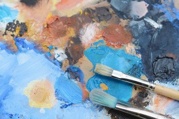 Colorful artist's palette with oil paint strokes.