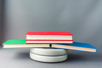 Multicolored books lie on gray pancakes from a sports bar