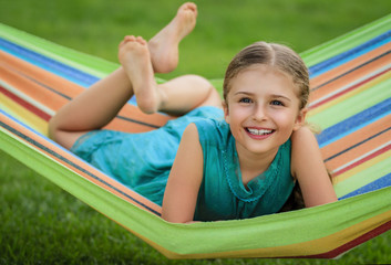 Young girl relaxing on the hammock in garden.