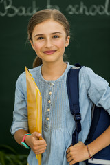 Beatiful smiling pupil in classroom at the elementary school, back to school.