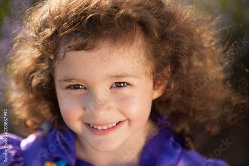 Portrait Of Smiling Beautiful Little Girl With Brown Curly