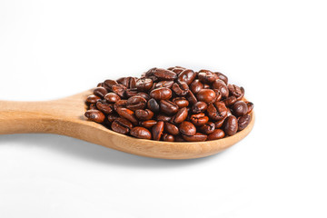 Obraz premium Close up of coffee bean on wooden spoon isolated on a white background.
