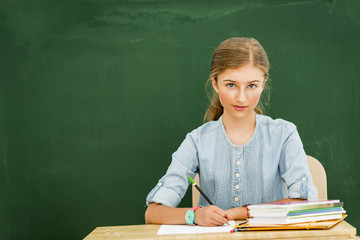 Beatiful smiling pupil in classroom at the elementary school, back to school.