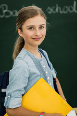 Beatiful smiling pupil in classroom at the elementary school, back to school.