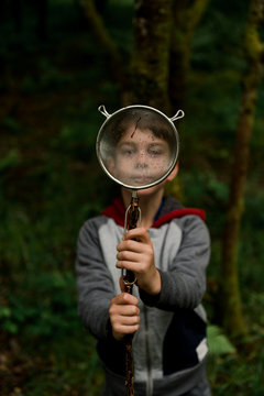boy looking through sieve
