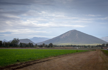 Fototapeta premium A cloudy winter sky over fields, farmlands adnd the mountains of the Great Dividing Range in Queensland, Australia