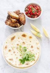 Homemade delicious food of tortillas, salsa and fried wings.