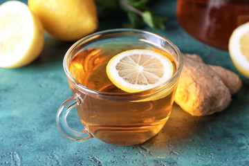 Cup of hot tea with ginger and lemon on table