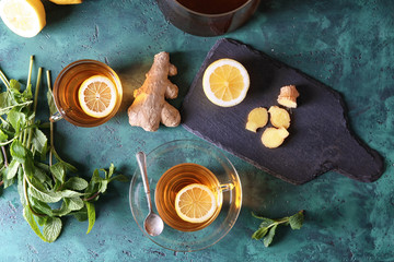 Cups of hot tea with ginger and lemon on table