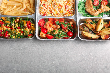 Food delivery containers with different meals on light table, top view