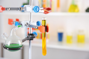 Stand with test tube and laboratory glassware against blurred background