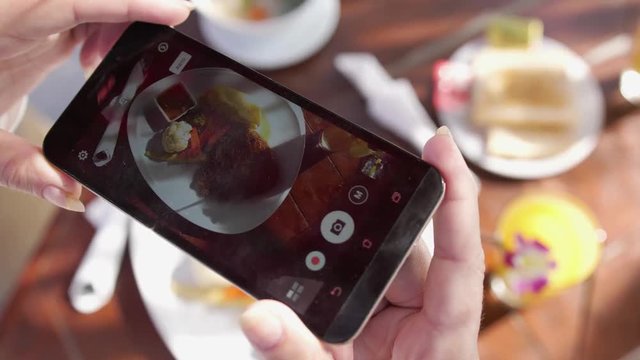 Close up of woman hands taking photos of dinner food by smartphone. slow motion. 3840x2160