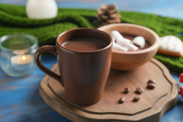 Cup of tasty hot chocolate with marshmallow on wooden board