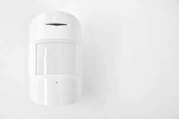Modern motion sensor on wall indoors