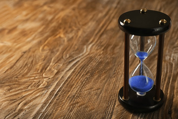 Hourglass on wooden background. Time management concept