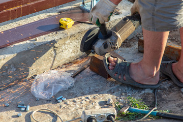 Worker cuts metal on a building site
