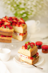 Obraz na płótnie Canvas Homemade strawberry cake on a glass stand on the white background.