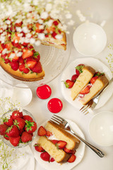 Homemade strawberry cake on a glass stand on the white background.